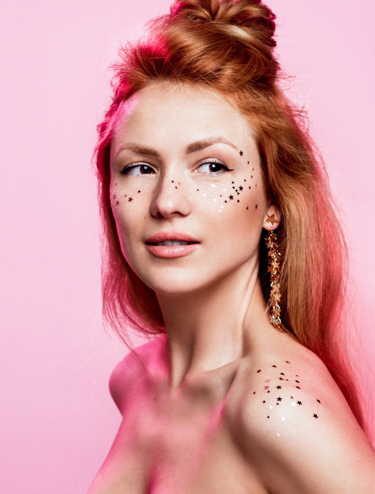 young woman with red hair and glitter on her face