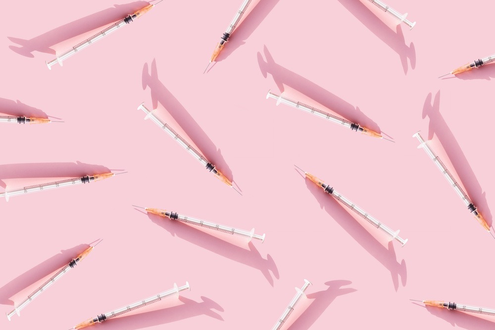 injection needles on pink background